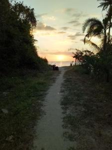 een onverharde weg die bij zonsondergang naar het strand leidt bij Nas Villaria Langkawi in Pantai Cenang