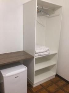 um armário com um armário branco e um frigorífico em Hotel Luz do Sol no Balneário Camboriú