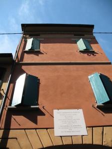 un bâtiment avec deux fenêtres et un panneau sur celui-ci dans l'établissement Casa Mozart, à Bologne