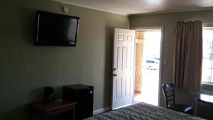 a bedroom with a bed and a television on the wall at Santa Ana Travel Inn in Santa Ana +25 photos