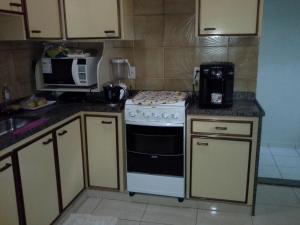 a kitchen with a stove and a microwave at casa duplex sergio e claudia in Vitória