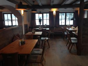 a restaurant with wooden tables and chairs and windows at Gasthaus Aiplspitz in Bayrischzell