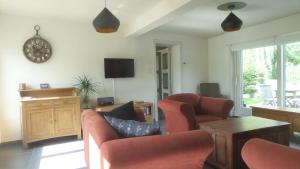 a living room with chairs and a clock on the wall at Doeselie in Ronse