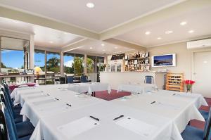 a row of tables in a room with white tables at Ringwood Lake Inn in Ringwood