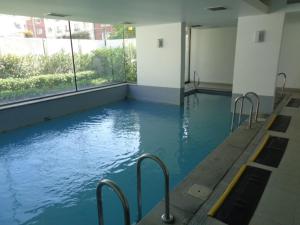 uma grande piscina com água azul num edifício em Delpino Propiedades Sector Casino em Viña del Mar