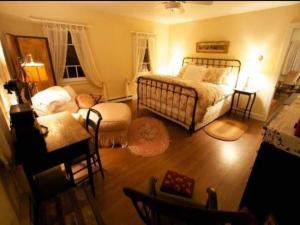 a bedroom with a bed and a chair and a table at Inn at Fox Hill Farm in Pomfret