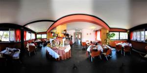 リニャーノ・サッビアドーロにあるHotel Savoiaのテーブルと椅子が備わるレストラン