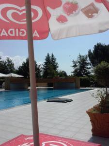 parasol stojący przed basenem w obiekcie Hotel Likos w mieście Grumento Nova