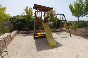a playground with a yellow slide and a swing at Petroto Villas in Kiotari