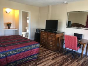 Habitación de hotel con cama, escritorio y TV. en Motel 6 Richmond CA Civic Center, en Richmond