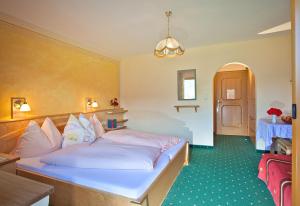 a bedroom with a large white bed in a room at Pension Schwab in Taxenbach