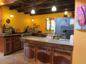 cocina con paredes amarillas y encimera grande en Agua Inn, en Nuevo Arenal