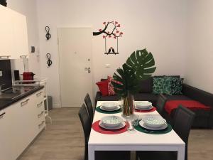 una cocina y una sala de estar con una mesa con platos. en Casa Ohana, en Ancona