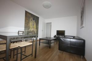 un soggiorno con tavolo e scrivania di Swiss Star Residences - Self Check-In a Zurigo
