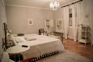 a bedroom with two beds and a table and a chandelier at La Pausetta in Foligno