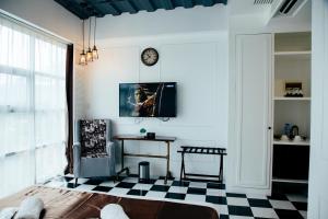 a living room with a clock and a checkered floor at Facade Hotel in Tabaco