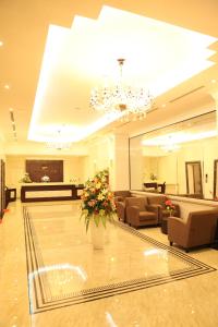 a large lobby with couches and a flower vase at Ha Long DC Hotel in Ha Long