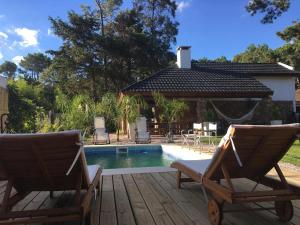 un par de sillas sentadas en una terraza junto a una piscina en Bebek B&B, en Punta del Este