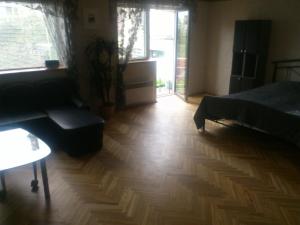 salon z łóżkiem i drewnianą podłogą w obiekcie Muuli Ranna Hostel w Parnawie