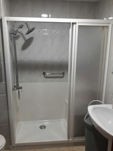 a shower with a glass door next to a sink at Apartamento Avenida Parque in Córdoba