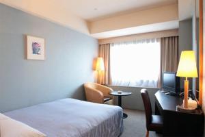 Postel nebo postele na pokoji v ubytování Yokohama Techno Tower Hotel
