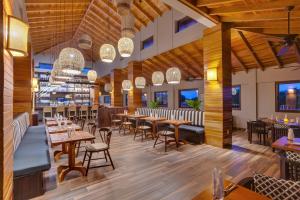 a restaurant with wooden floors and tables and chairs at Naïa Resort and Spa in Placencia Village