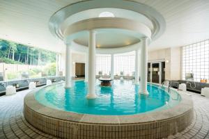 a pool in the middle of a building with columns at Nishiizu Crystal View Hotel in Nishiizu