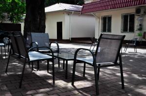 um grupo de cadeiras e uma mesa em frente a uma árvore em Old Courtyard Hostel em Odessa