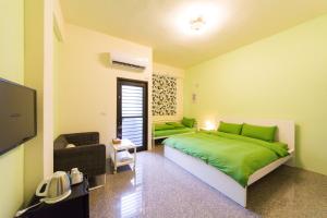 a bedroom with a green bed and a couch at Nice Guanxi in Guanxi