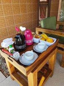 uma mesa de madeira com comida em cima em Pousada Suites do Santinho em Florianópolis