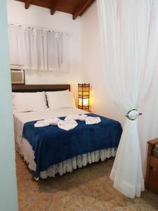 um quarto com uma cama com toalhas em Pousada Suites do Santinho em Florianópolis mais 55 fotografias