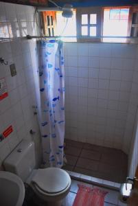 a bathroom with a toilet and a shower curtain with fish at Prive das Acacias in Porto De Galinhas +26 photos