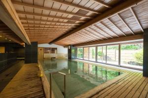 an indoor swimming pool with a wooden ceiling at Nishiizu Crystal View Hotel in Nishiizu