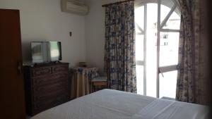 a bedroom with a bed and a tv on a dresser at Casa de Alvor in Alvor