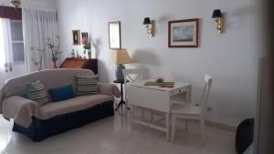 a living room with a couch and a table and a desk at Casa de Alvor in Alvor