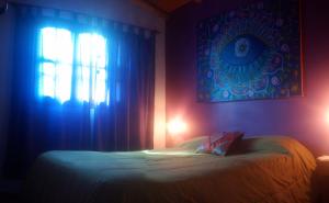 1 dormitorio con 1 cama y una ventana con luces azules en Amaltea en Villa Las Rosas