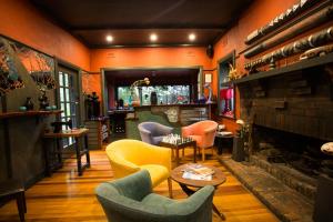 a living room with colorful chairs and a fireplace at Oakdene Vineyards Guesthouse in Wallington