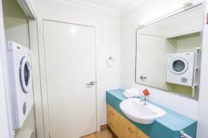 a bathroom with a sink and a washing machine at Auski Hideaway in Agnes Water