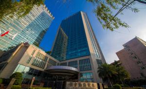 a tall building with a large blue cross on it at Galaxy minyoun Chengdu Hotel in Chengdu