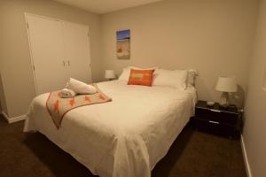 een slaapkamer met een groot wit bed met oranje kussens bij Epsom Apartments in Auckland