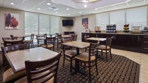 a restaurant with tables and chairs and a bar at Best Western Lumberton in Lumberton