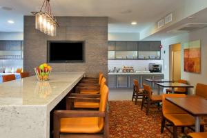 a kitchen and dining room with a large counter and chairs at Hyatt House Houston Galleria in Houston