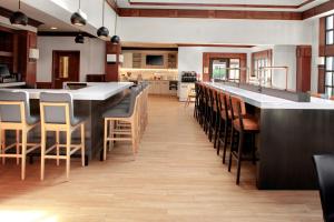 a large kitchen with a long bar and chairs at Hyatt House Morristown in Morristown