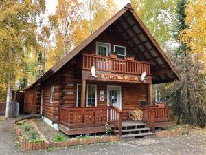 um chalé de madeira com um alpendre e uma varanda em Sven's Basecamp Hostel em Fairbanks