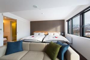 a bedroom with two beds and a couch at Always Niseko in Niseko