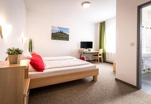 Un dormitorio con una cama y un escritorio. en Hotel an der Burg, en Giessen