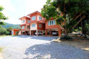 a large orange house with a tree in front of it at Baan Pordee Homestay in Phayayen