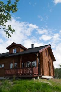 ein großes Holzhaus mit einer großen Terrasse in der Unterkunft Kilpisjärven Tunturimajat in Kilpisjärvi