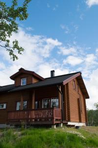 a large wooden house with a large deck at Kilpisjärven Tunturimajat in Kilpisjärvi