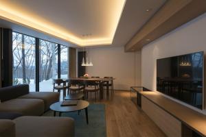 a living room with a couch and a tv and a table at Kozue in Niseko
